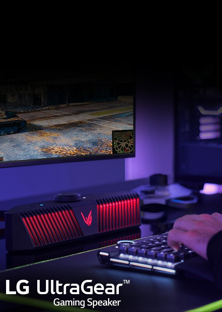 A gaming speaker is placed in a fancy dream setup with purple lighting room and a man is playing a game but only his hand is showing.