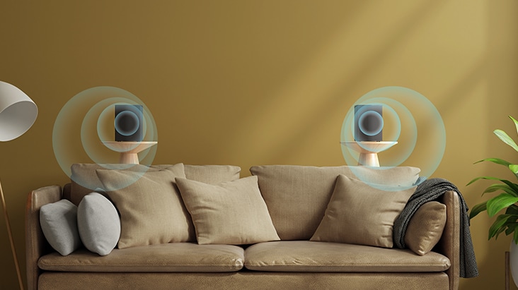 Two rear speakers are placed on a side table behind the sofa with virtual sound effect implying sound going-forward.