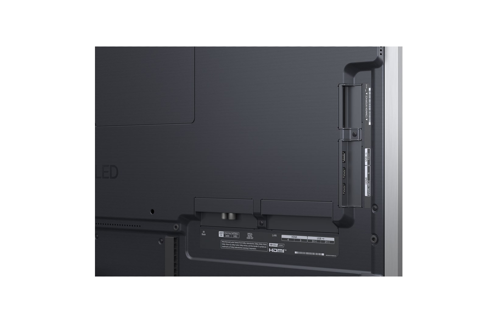 Stor vy över ett vardagsrum i ett lyxhem där en man tittar på en film på sin väggmonterade LG OLED TV. Tv:ns design smälter elegant in i väggen och inredningen.