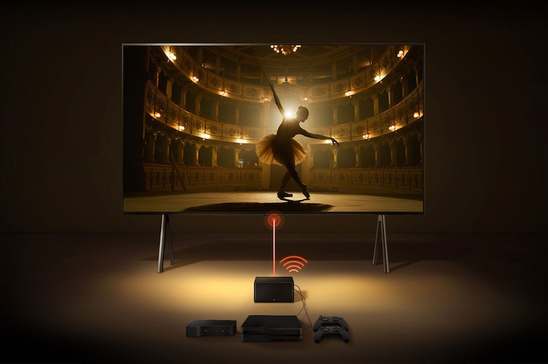 En Zero Connect Box framför en LG SIGNATURE OLED M4 och en röd Wi-Fi-signal och röd stråle som sänds ut mot TV:n. TV:n visar en ballerina som dansar solo på scenen.