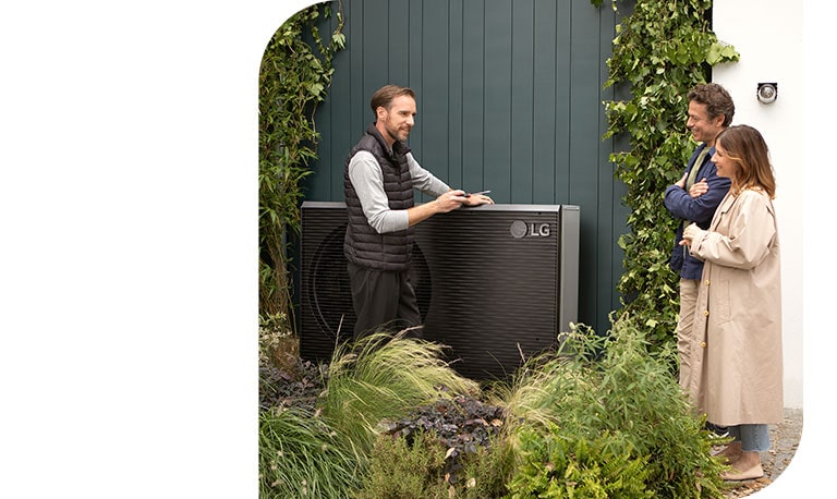 En ingenjör står bredvid en ny svart THERMA V och pratar med ett ungt par medan de installerar LG luft-vattenvärmepump.