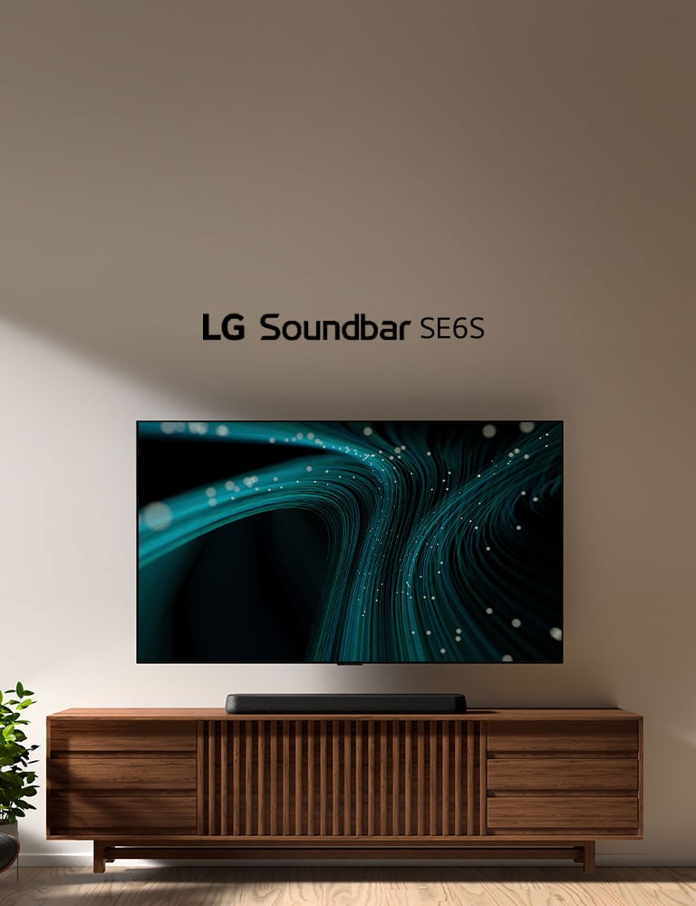 LG Sound Bar SE6S står på ett träskåp. Ovanför sitter en väggmonterad TV som visar blå ljudvågor och ljuspunkter. På vänster sida syns en del av ett fönster. En vilstol i svart läder står framför en grön växt.