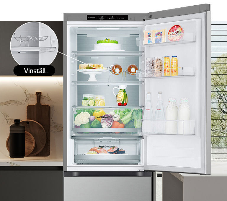 Ett kylskåp fullt med färsk mat med dörren öppen som visar vinställ och vikbar hylla.
