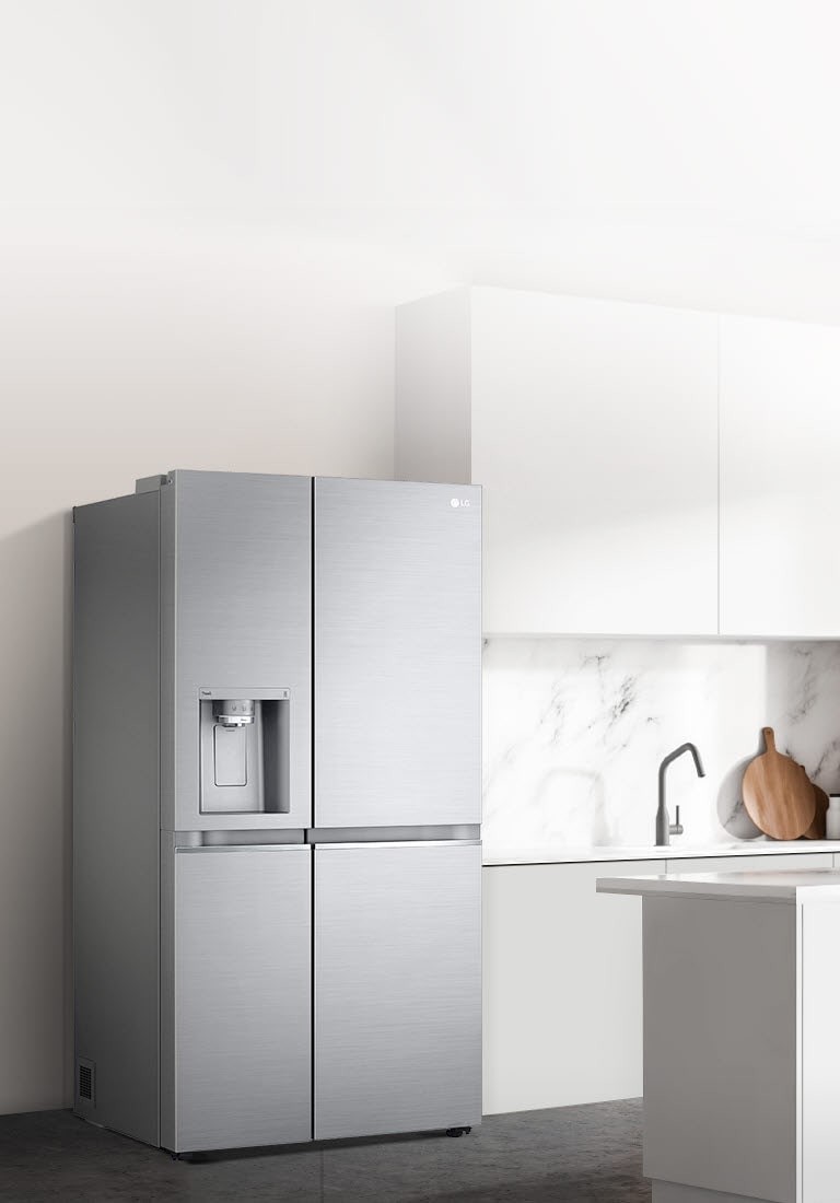 A side view of a kitchen with a refrigerator installed.