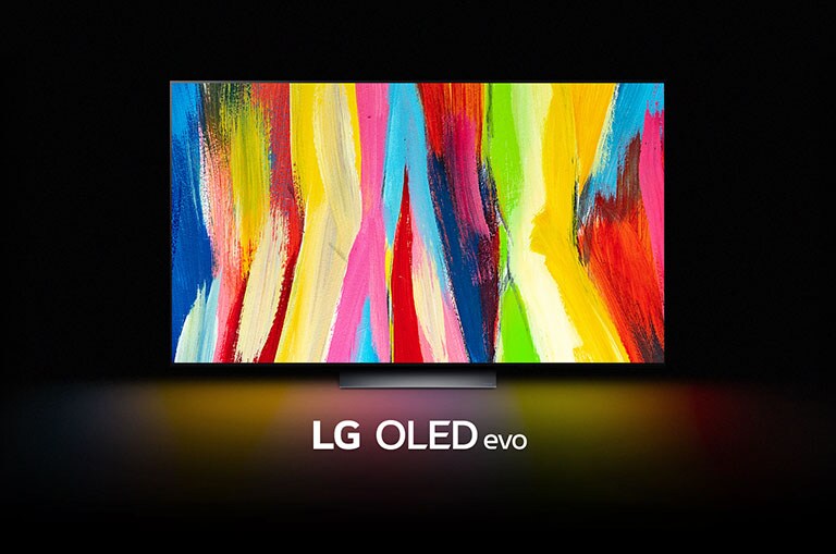 En LG OLED C2 står i ett mörkt rum med ett färgglatt abstrakt konstverk av vertikala linjer på skärmen och orden "LG OLED evo" undertill.