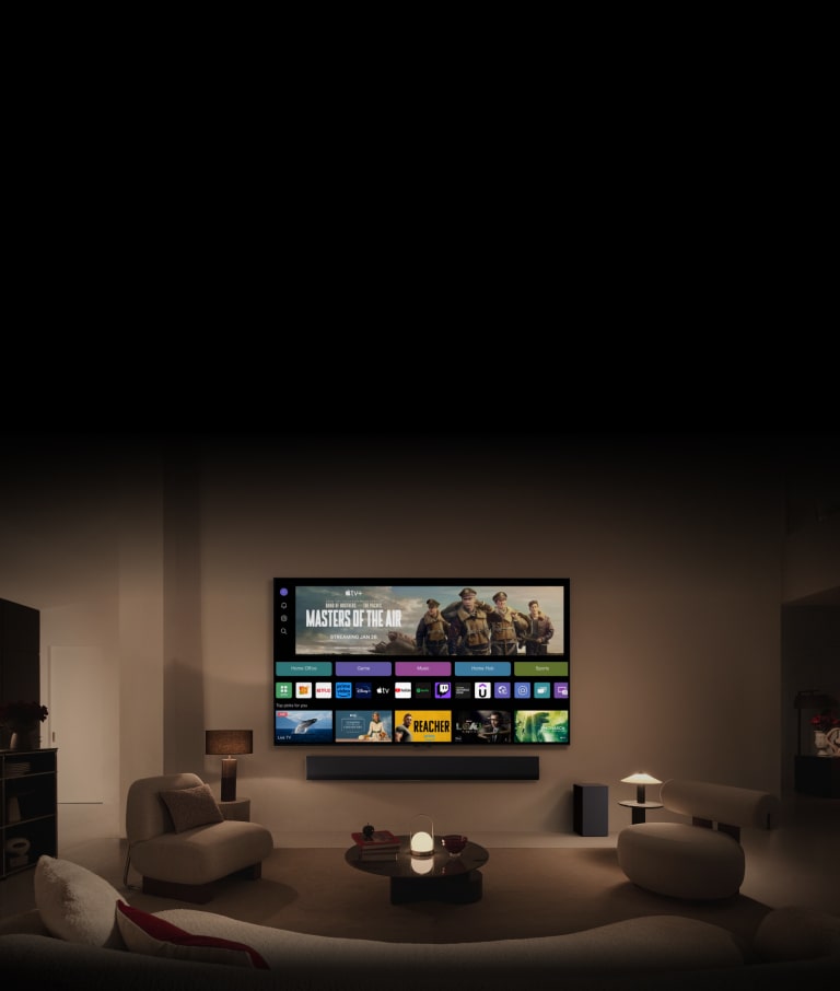 En närbild av en LG TV-skärm som visar knapparna Home Office, Game och Music över en banner för Masters of the Air som zoomar ut för att visa TV:n monterad på en vägg i ett vardagsrum. Följande logotyper visas på TV-skärmen i bilden: LG Channels, Netflix, Prime Video, Disney TV, Apple TV, YouTube, Spotify, Twitch, GeForce Now och Udemy.