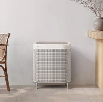 Minimalist white LG air purifier blending seamlessly into a warm, modern room interior.