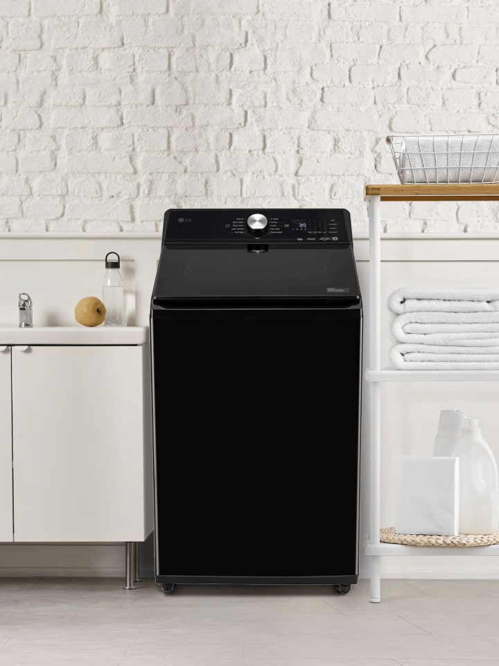 LG top load washing machine in a space with a sink and laundry supplies.