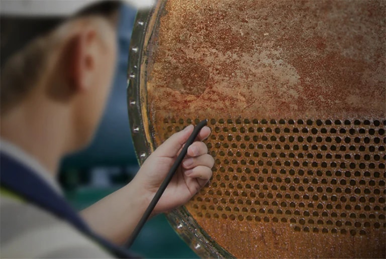 An engineer is cleaning dirty tubes.