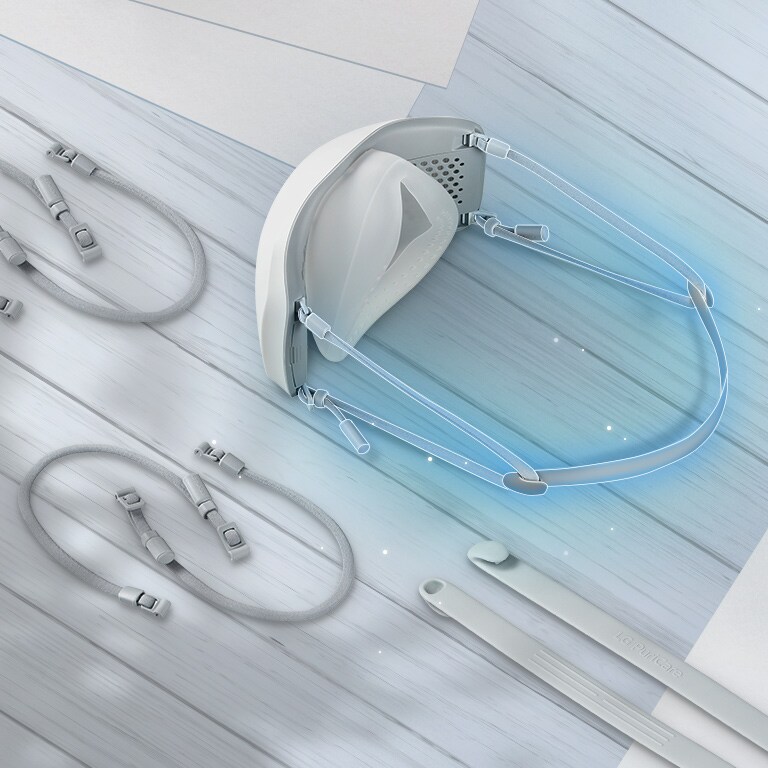 The top and interior of the mask is shown with the elastic fabric band connected in the back and highlighted in blue. Extra elastic fabric bands are on the table around the mask.