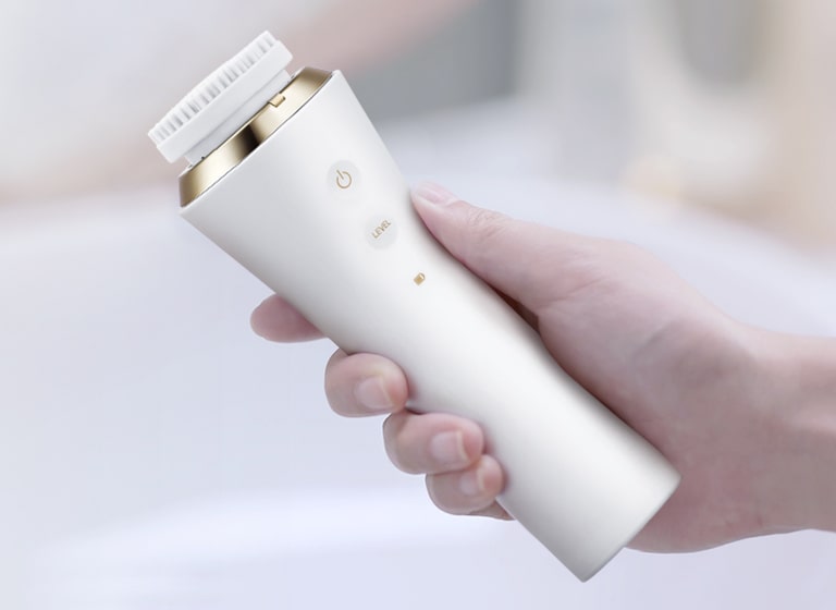 Hand model holding onto LG Pra.L Dual Cleanser in white, BCL 1