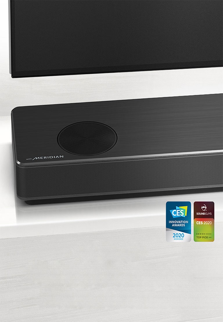 Close-up of LG Soundbar left side with Meridian logo shown on bottom left corner. Bottom left side of TV is also visible.