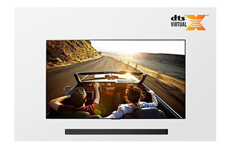 TV and Soundbar together in full view. TV shows a couple in an open roof car on the road driving into the sunset.