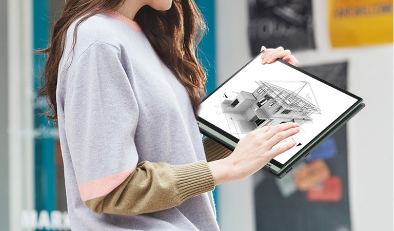 A woman is carrying her LG gram2in1, while she checking a design work on it on the way.