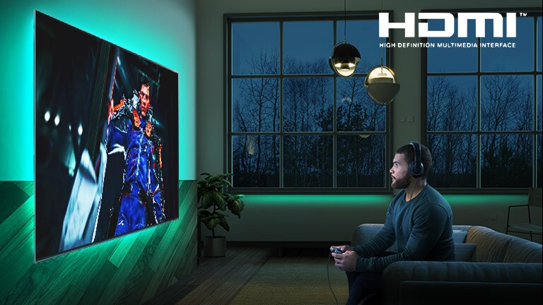 Man sitting on a sofa, holding a joystick while playing a RPG game on a TV screen