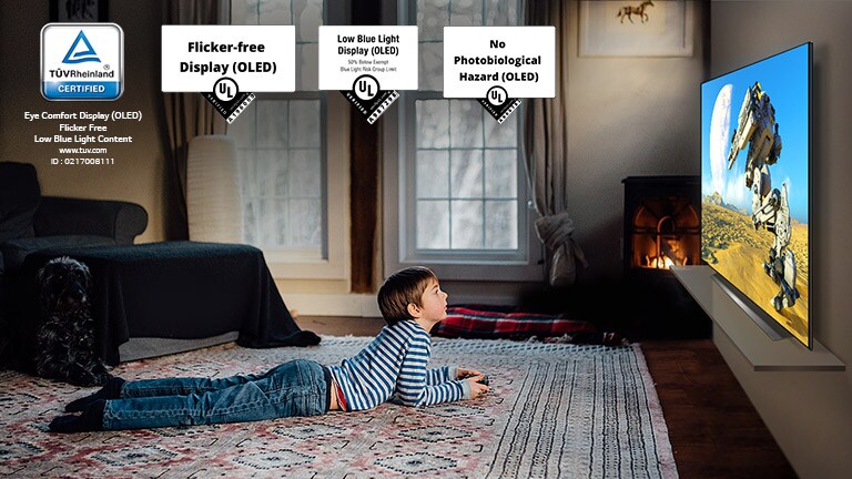 Child lying on the floor, holding a joystick and playing a game on a TV screen