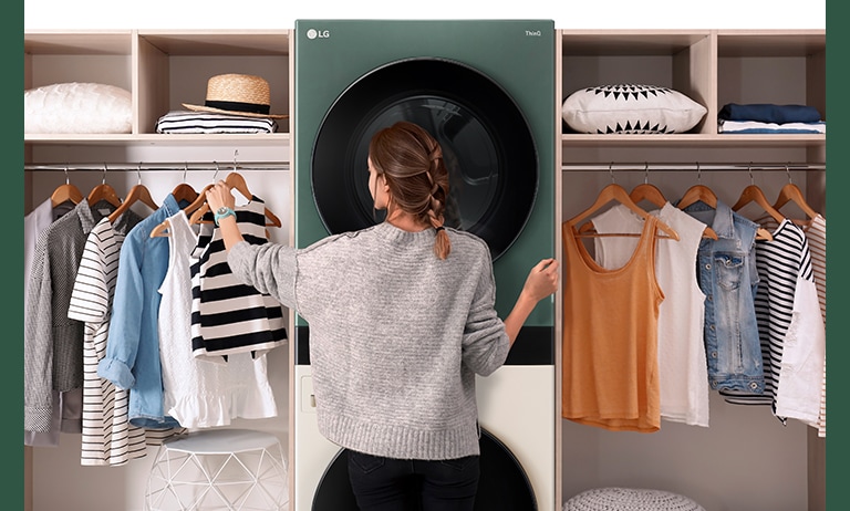 A WashTower is installed between the hangers, and a woman is choosing clothes in front.