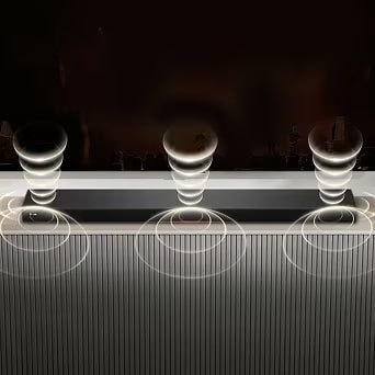 A soundbar emitting rich, immersive sound wave patterns from its top and bottom.