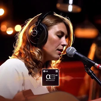 Woman singing into a microphone with headphones, her vocal performance enhanced by LG's α11 AI Processor — illustrating how AI Sound Wizard remasters voice clarity in real time on LG AI TVs.