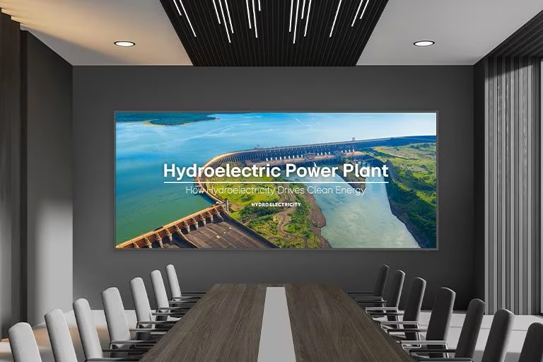 A wide display is installed on the wall of the spacious conference hall, and presentation is prominently and clearly displayed on the large screen.	