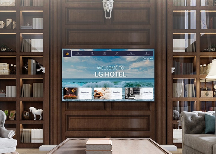 A luxury hotel room features a central TV equipped with LG Pro:Centric, displaying a welcoming message to guests.	