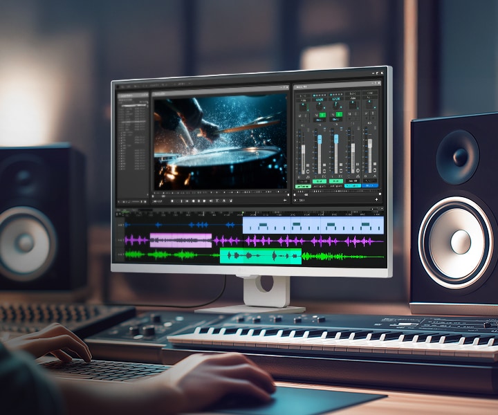 LG Smart Monitor displaying a professional video and audio editing workspace with timeline, color grading tools, and sound mixing interface, highlighting IPS 4K resolution, HDR support, and wide color coverage in a creative studio setup with speakers and keyboard for content production and multimedia work.