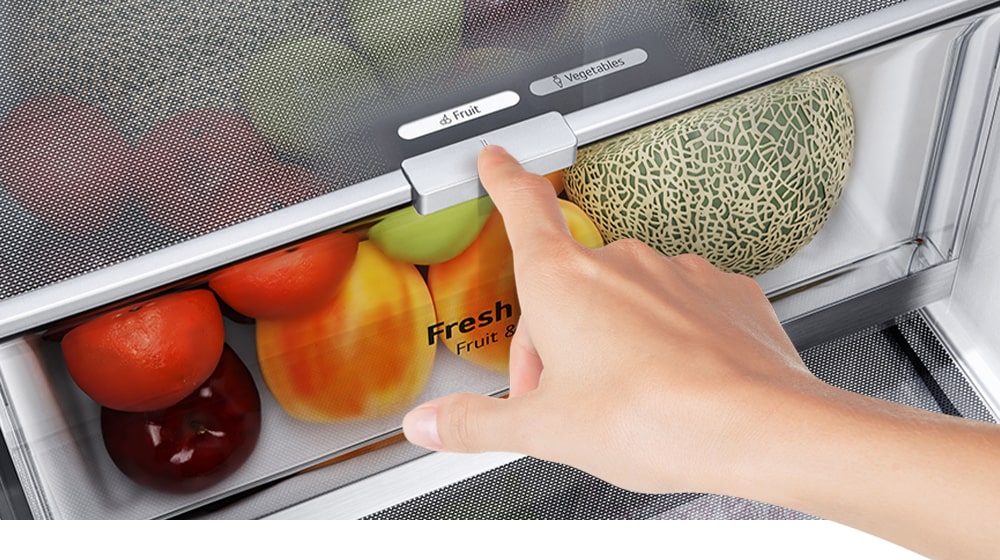 The bottom drawers of the fridge are filled with colorful fresh produce. An inset image magnifies the control lever to choose the optimal humidity level to keep produce fresh.