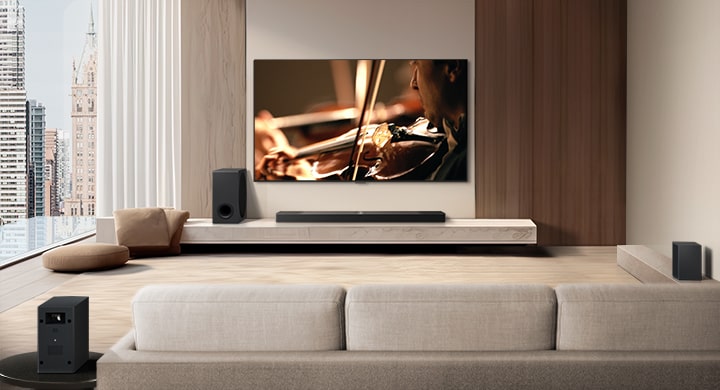 A video shows an LG TV, LG Soundbar, Rear Speakers, and Sub Woofer from behind the sofa in a modern city apartment. The Rear Speakers and Wireless Receiver light up, and a grid overlay appears over the image like a scan of the space. White beads of sound come together to make waves, then project from each part of the sound system, perfectly filling the room with sound. 