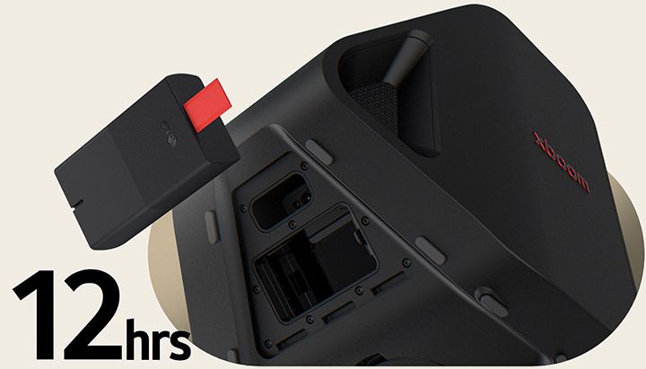 Rear side of Stage 301 is shown with its battert part open. A replaceable battery is hanging on the air right next to the xboom Stage 301.