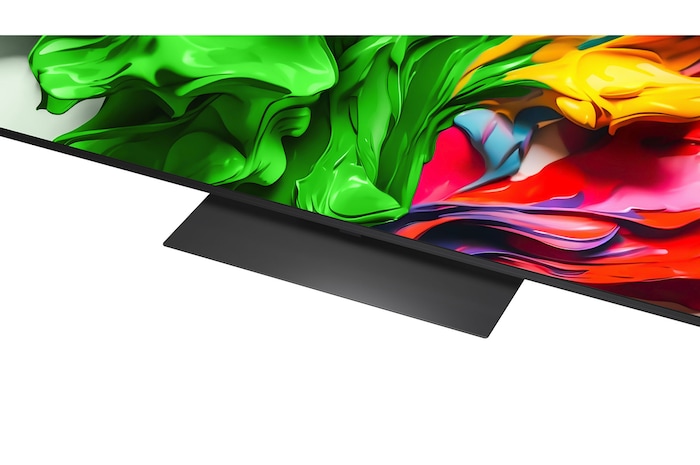 A girl and a dog are seated in front of a LG QNED TV mounted on a wall depicting three elephants walking outwards above a LG Soundbar. The title talks about how every action is more thrilling on a massive screen.