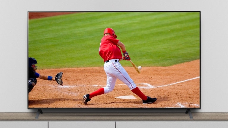 The TV is on the stand, and the screen shows a baseball match.