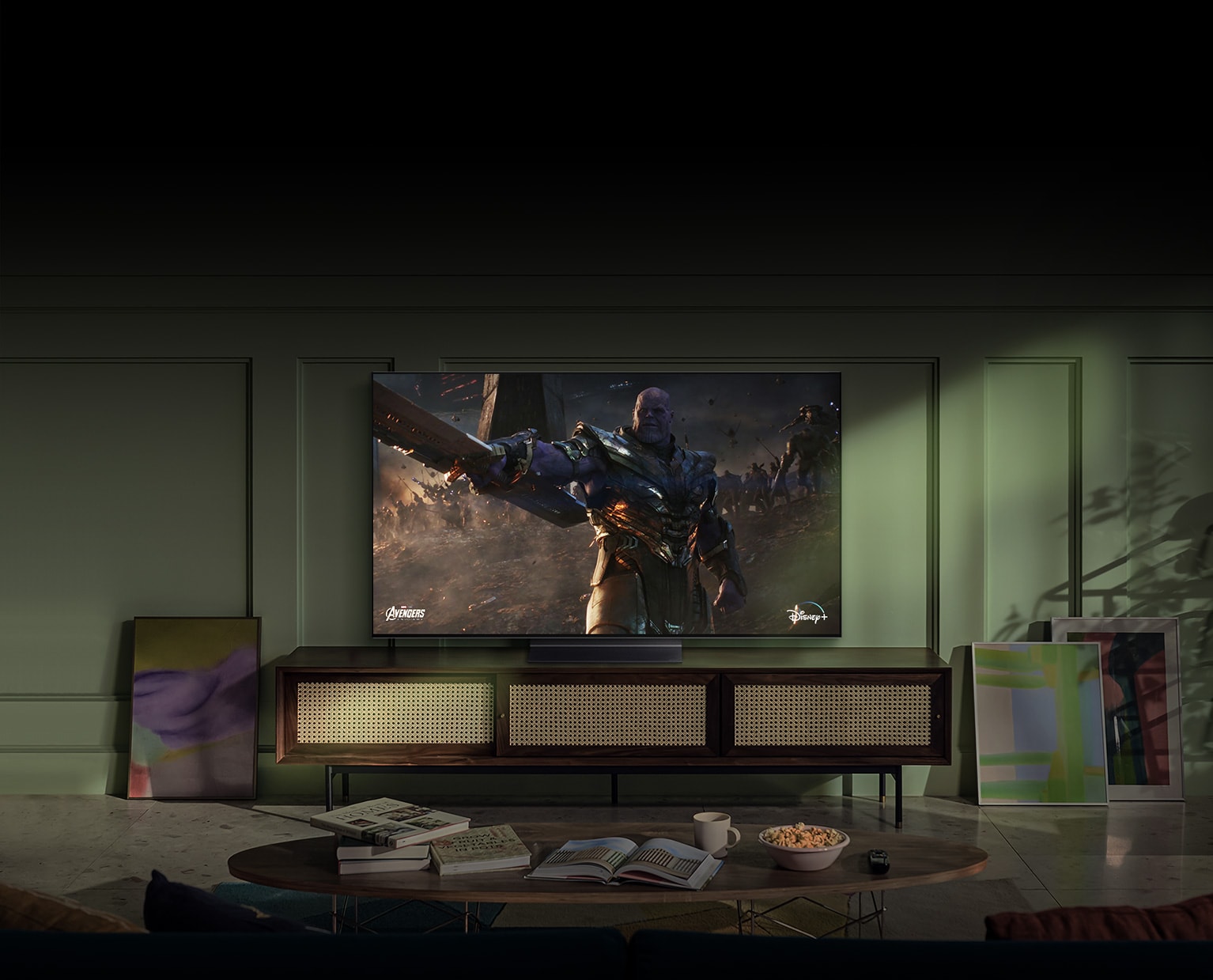 A large wall-mounted LG OLED television shows an action movie scene