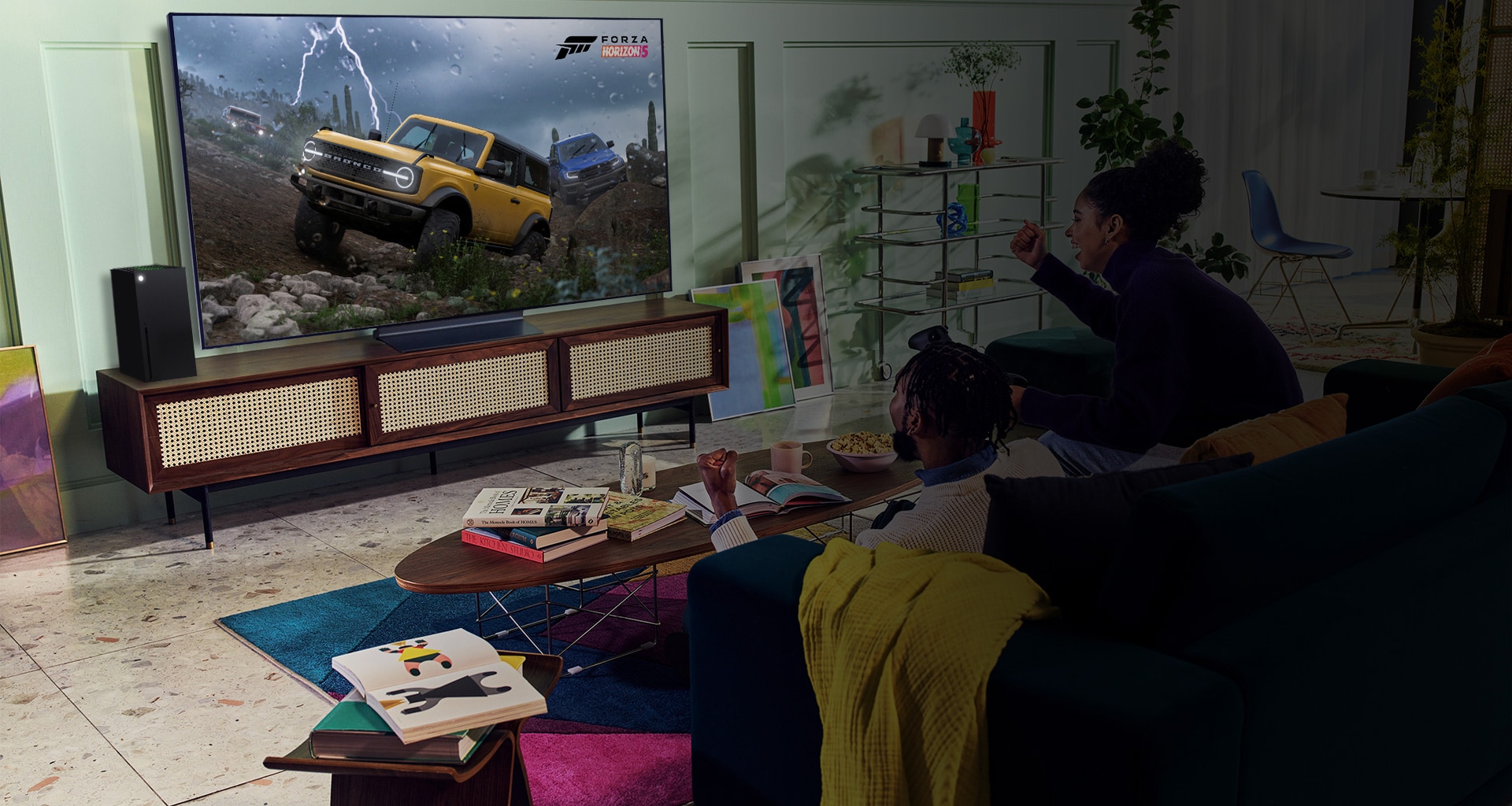 A person plays a racing game with an XBOX Series X controller on an LG OLED television