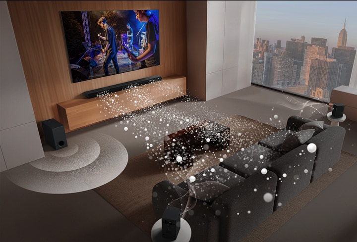 LG Soundbar, LG TV และซับวูฟเฟอร์อยู่ในห้องนั่งเล่นที่แสดงภาพหน้าจอพร้อมการเล่นดนตรี คลื่นเสียงสีขาวสามกิ่งที่ประกอบด้วยหยดที่ฉายออกมาจากซาวด์บาร์และซับวูฟเฟอร์กำลังสร้างเอฟเฟกต์เสียงจากด้านล่าง