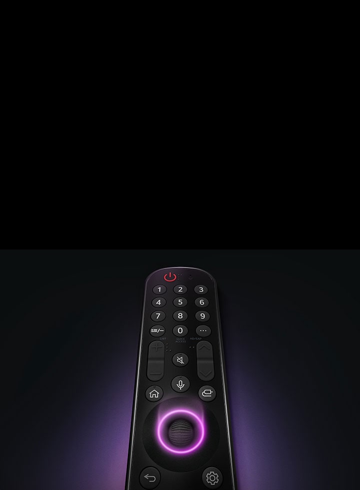 LG Magic Remote ที่มีปุ่มวงกลมตรงกลาง โดยมีแสงสีม่วงนีออนเล็ดลอดออกมารอบๆ ปุ่มเพื่อไฮไลต์ แสงสีม่วงอ่อนๆ ล้อมรอบรีโมทบนพื้นหลังสีดำ