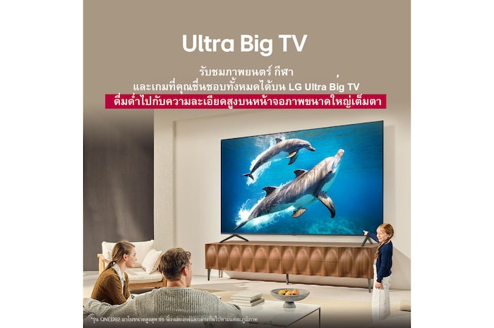 ครอบครัวหนึ่งนั่งอยู่บนโซฟาหันหน้าไปทาง LG QNED TV วางอยู่บนแท่นวางทีวี โดยมีเด็กผู้หญิงตัวน้อยกำลังชี้ไปที่หน้าจอที่มีภาพปลาโลมาสองตัว หัวข้อพูดถึงการที่คุณสามารถเพลิดเพลินกับความละเอียดสูงได้บนหน้าจอขนาดใหญ่มาก