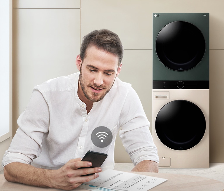 ผู้ชายกำลังตรวจสอบสถานะของ WashTower ผ่านทางแอป LG ThinQ
