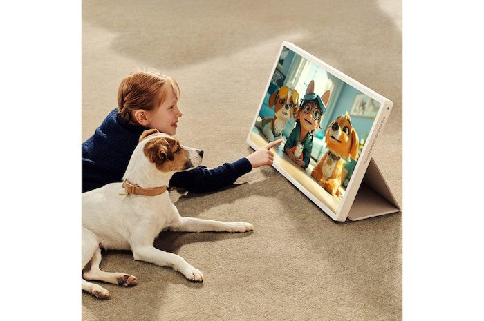 Köpeğiyle birlikte LG StanbyME 2’de bir program izleyen bir kız. Folyo kılıf kullanılarak ekran tablet gibi dik konumda tutulur. 