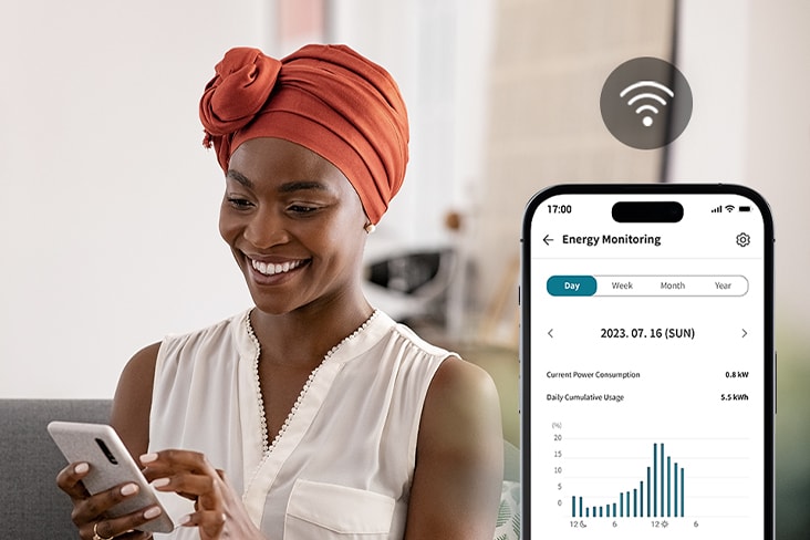 kW Manager’a sahip LG ThinQ uygulamasıyla enerji kullanımını ve tüketim grafiklerini telefondan görüntüleyen kadın.