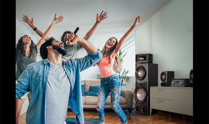 Bir grup insan oturma odasında karaokenin keyfini çıkarıyor ve yan tarafta LG MR11 gösteriliyor.