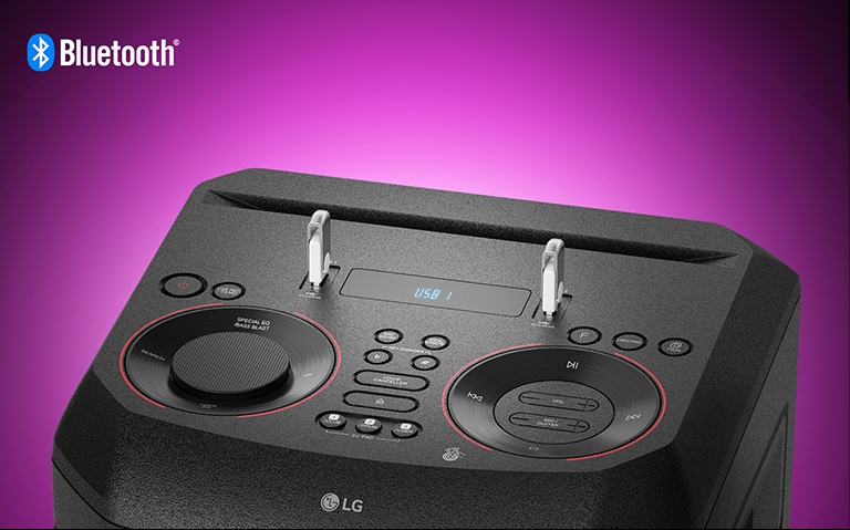 İki USB'nin takılı olduğu LG XBOOM'un üzerindeki kontrollerin yakın çekim görünümü. Sol üst köşede Bluetooth logosu gösterilir.