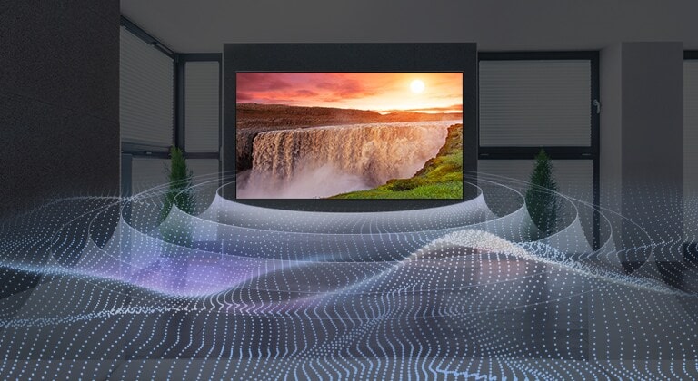 Karanlık bir odada, gün batımında aydınlık bir şelalenin gösterildiği büyük bir düz ekran TV. Dalgalar, sanal surround sesi temsil eden dairesel bir düzende TV'den yayılıyor.