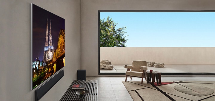 側視圖，客廳中有壁掛式安裝的 LG OLED G5 TV 和 LG Soundbar。這個角度突顯了其一體牆面設計，以及邊框和整體外型與牆面的緊密貼合。