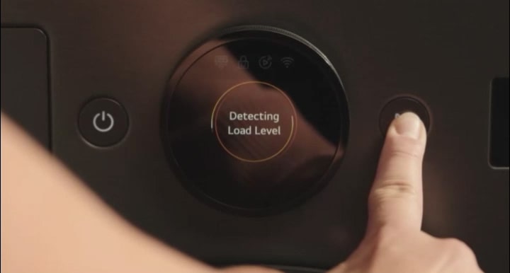 乾衣機控制面板的特寫影像,手指按下右側的操作按鈕。