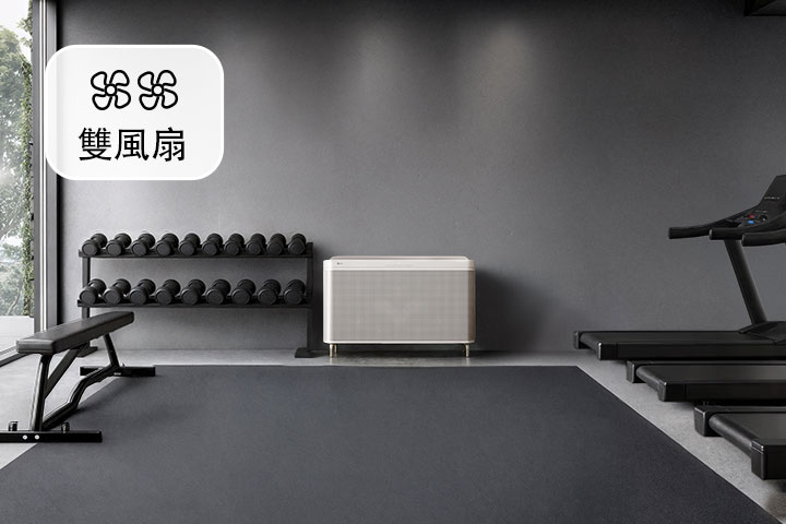 大型 LG 空氣清淨機，採用時尚的白色設計，放置於健身設備和跑步機之間。