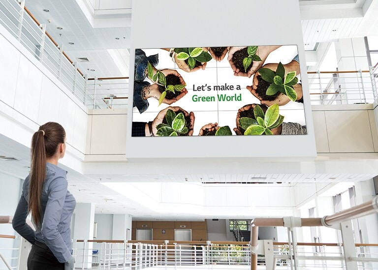 女人正看著安裝在樓上的螢幕。