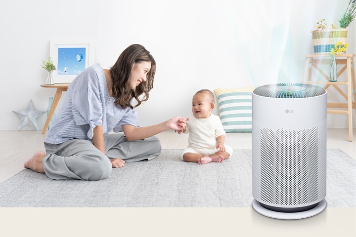 媽媽和寶寶在客廳裡玩得很開心。乾淨的空氣從右邊的空氣清淨機中排出來。