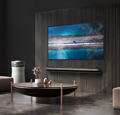 lg_signature_oled_tv_w掛在牆上，而lg_signature_airpurifier放在時尚的起居室旁。