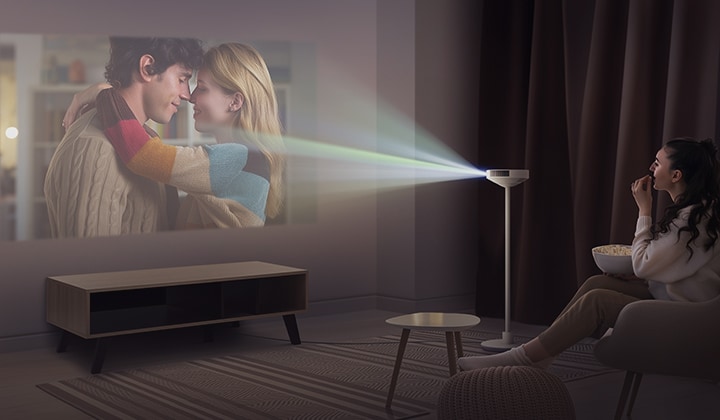 LG MoodMate 於舒適客廳空間投影大畫面，使用者於座椅上觀賞影片。