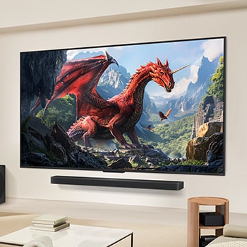一家人坐在沙發上，面向壁掛式安裝的 LG QNED TV，電視下方還配備 LG Soundbar。Zero Connect Box 則放在茶几下方。